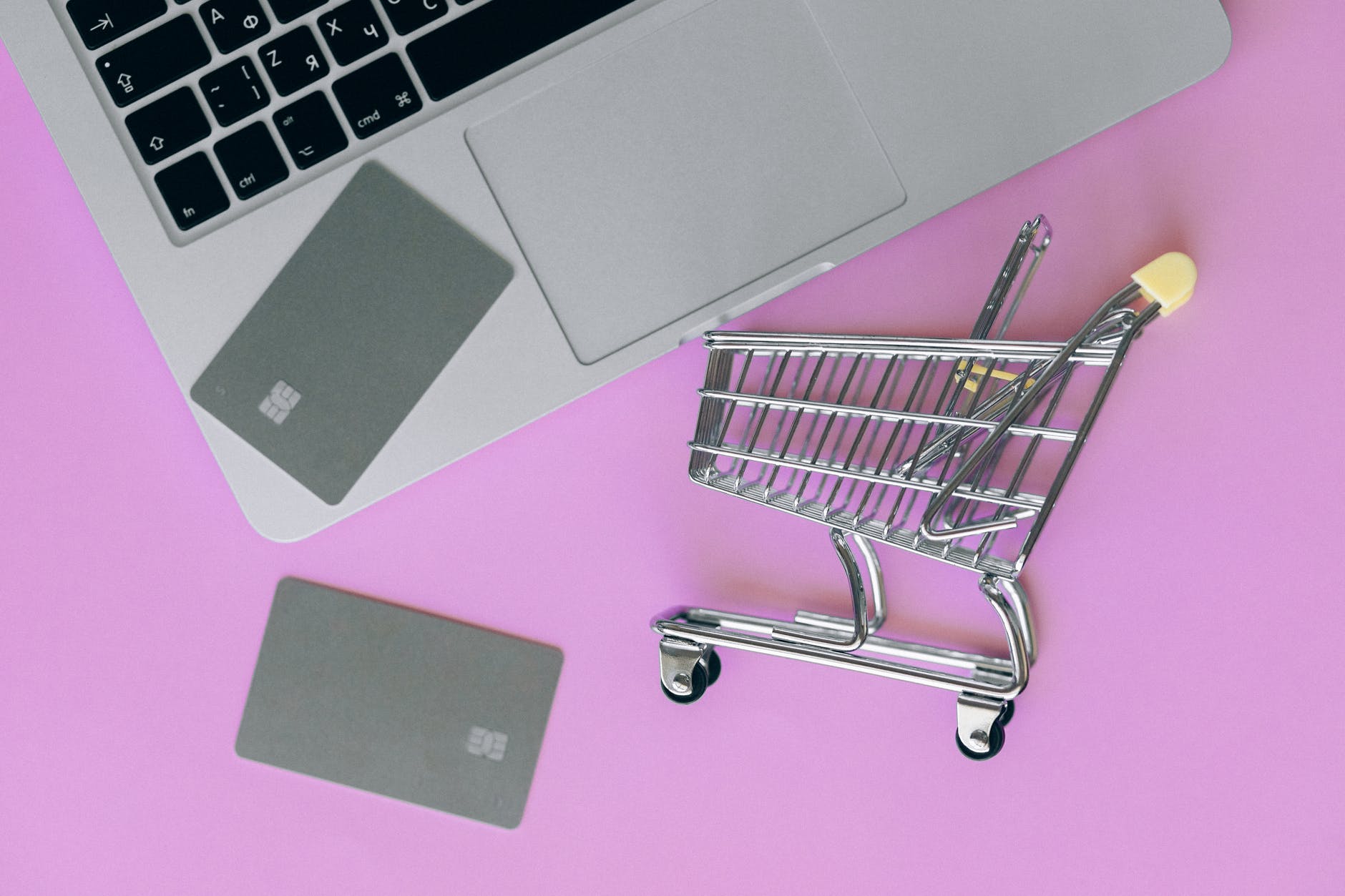 silver shopping cart on pink surface
